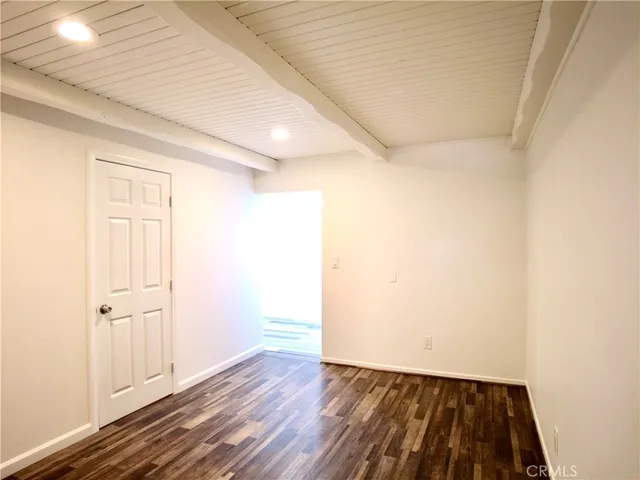 a view of a room with wooden floor and a window