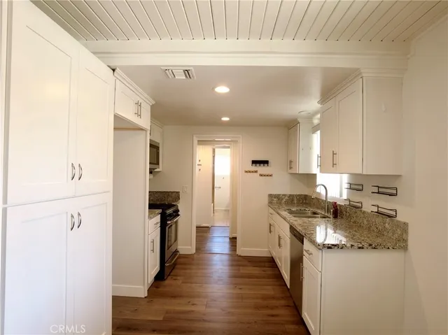 a kitchen with granite countertop stainless steel appliances and wooden cabinets