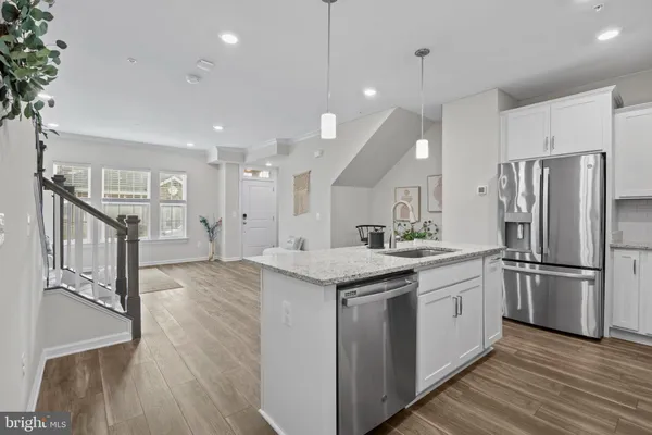 a kitchen with stainless steel appliances granite countertop a sink a refrigerator and a stove