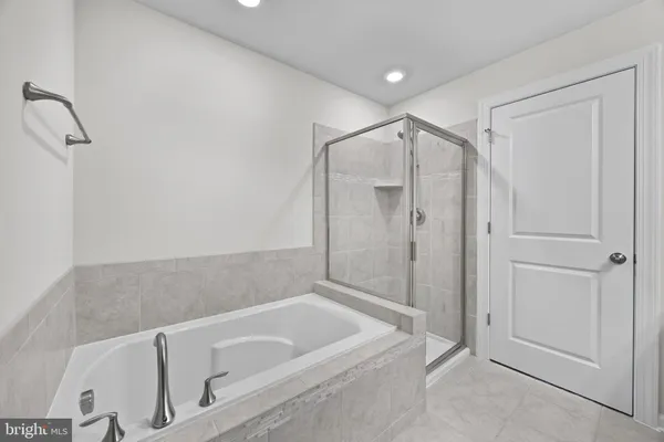 a bathroom with a tub a toilet and a shower