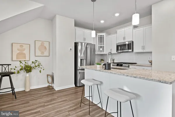 a kitchen with granite countertop a refrigerator stove microwave and sink