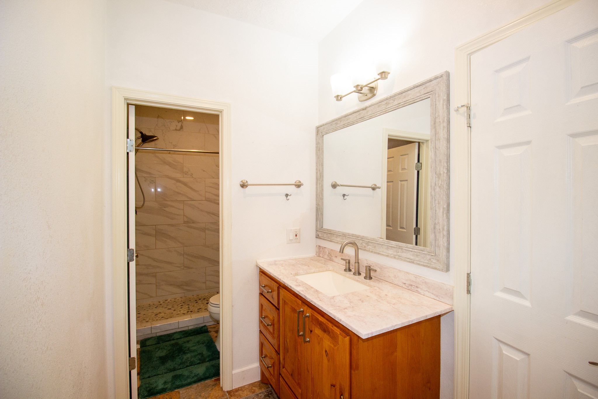 1245 4th Street Hempstead, TX 77445 - Photo 15 of 24 a bathroom with a sink a mirror and a shower