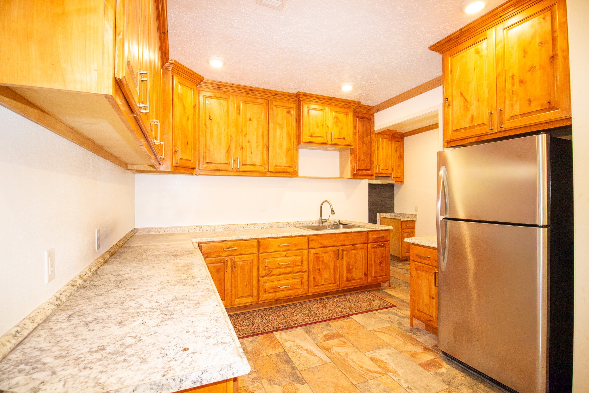 1245 4th Street Hempstead, TX 77445 - Photo 7 of 24 a kitchen with stainless steel appliances granite countertop a refrigerator a oven and white cabinets with wooden floors