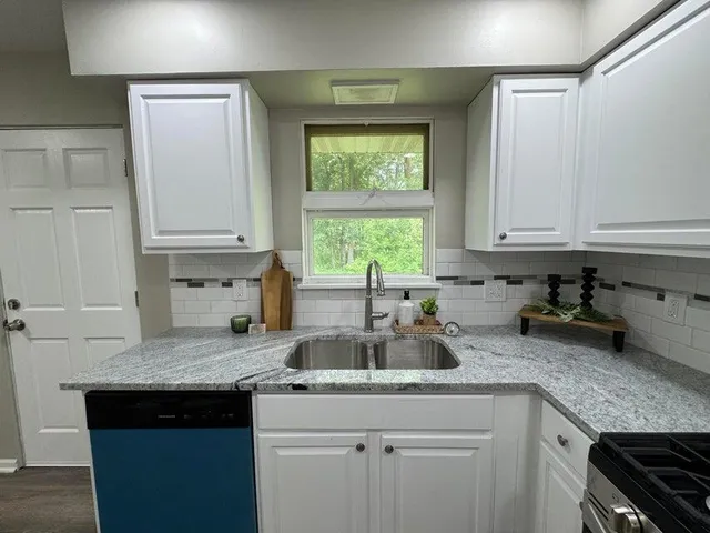 a kitchen with white cabinets and refrigerator