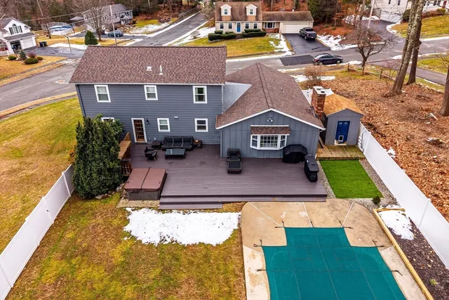 a aerial view of a house with swimming pool lawn chairs and a barbeque