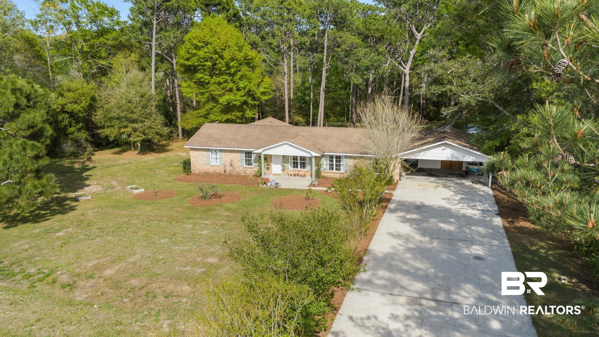 22800 River Road South Daphne, AL 36526 - Photo 4 of 52 View of front of home featuring a front yard, concrete driveway, and stone siding