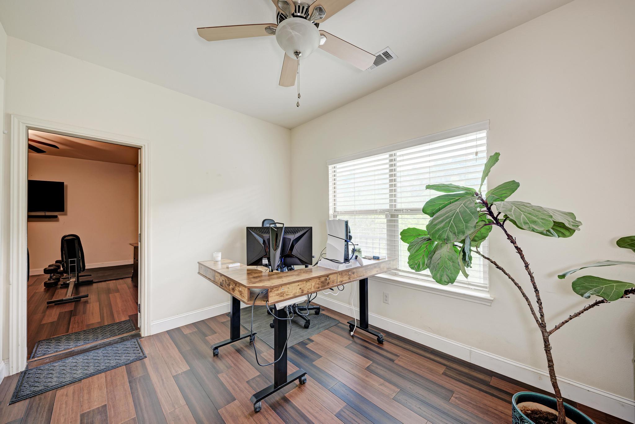 2605 Indian Creek Road Austin, TX 78734 - Photo 24 of 33 Bright interior space featuring wood-finish flooring, a ceiling fan, and a large window with white blinds