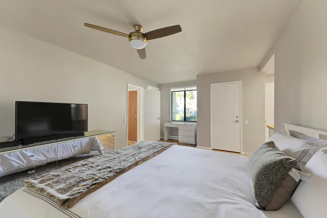 a bedroom with a bed and a flat screen tv