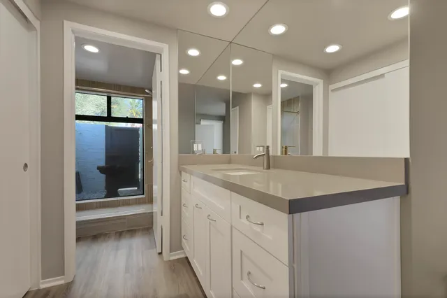a bathroom with a granite countertop sink a toilet and shower