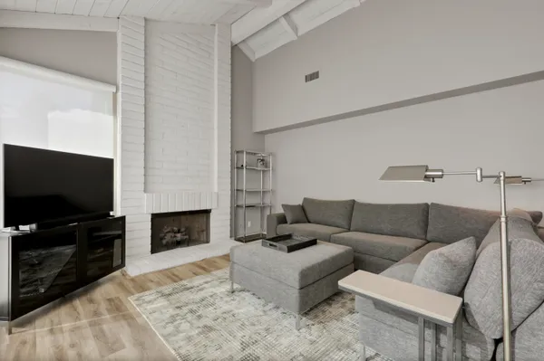 a living room with furniture a flat screen tv and a fireplace