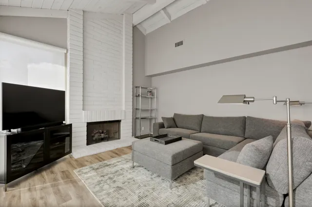 a living room with furniture a flat screen tv and a fireplace