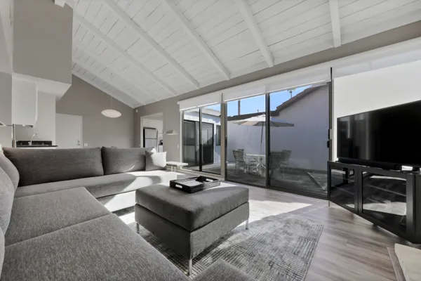 a living room with furniture a flat screen tv and a table