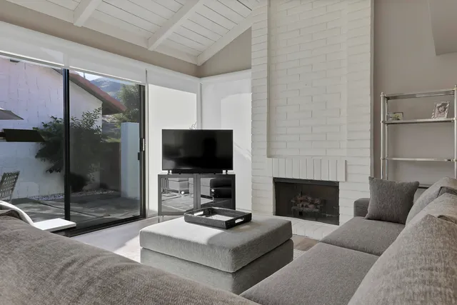a living room with furniture a flat screen tv and a fireplace