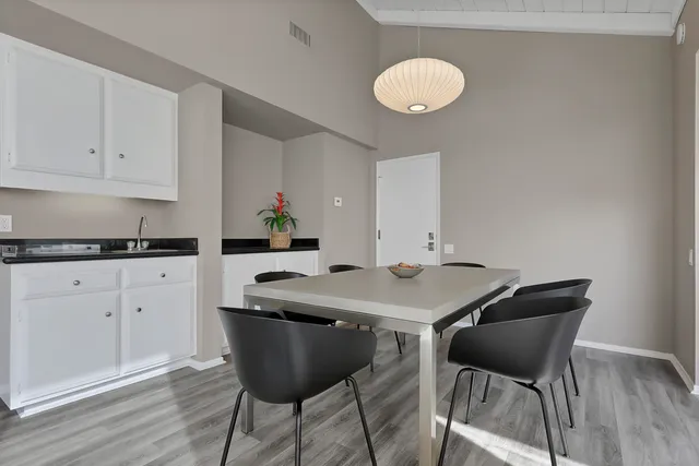 a kitchen with stainless steel appliances granite countertop a table and chairs in it