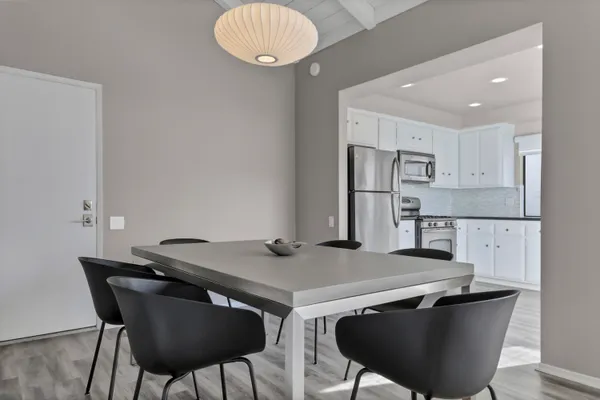 a kitchen with stainless steel appliances a table chairs and a refrigerator