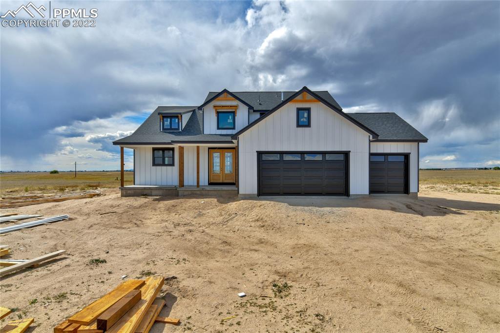 2420 North Log Road Calhan, CO 80808 - Photo 17 of 47 a front view of a house with a yard and garage