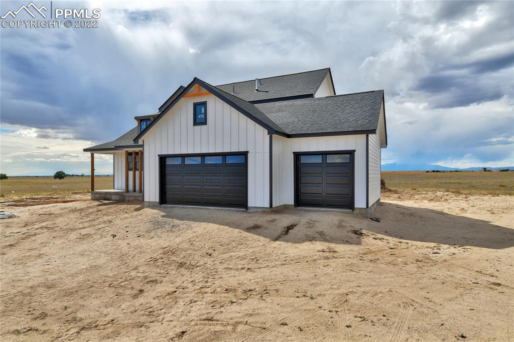 2420 North Log Road Calhan, CO 80808 - Photo 19 of 47 a front view of a house with a yard and garage