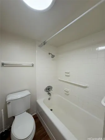 a white toilet sitting next to a bath tub