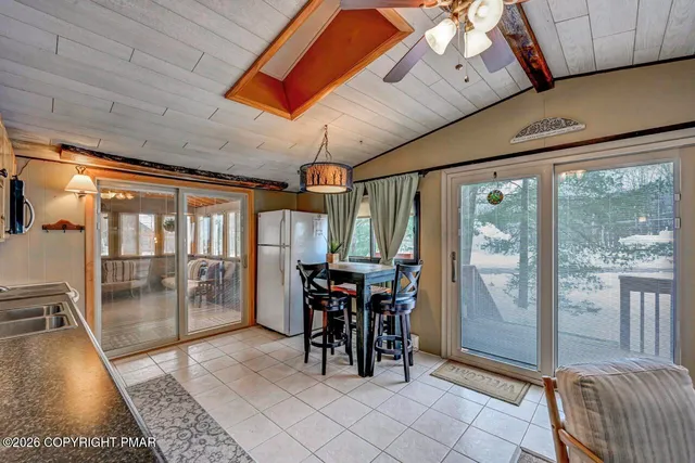 a living room with furniture a ceiling fan and a large window
