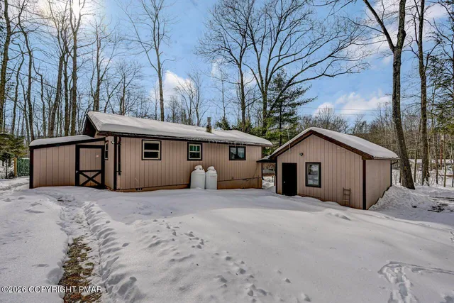 a view of a house with a yard covered in snow