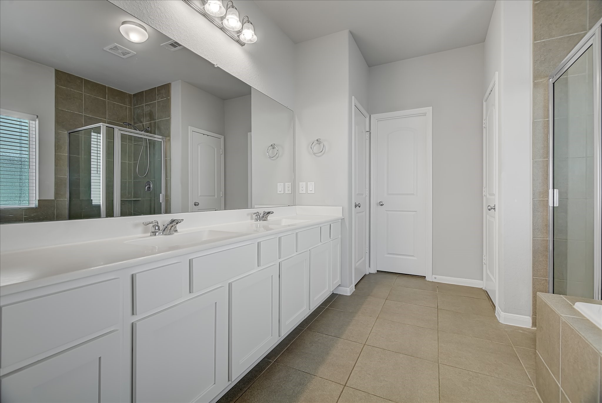 6014 Prince Place Drive Rosenberg, TX 77471 - Photo 13 of 28 The primary bathroom includes a dual-sink vanity with ample counter space and cabinetry, making busy mornings easier.