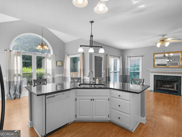 a view of living room with granite countertop furniture a fireplace and chandelier