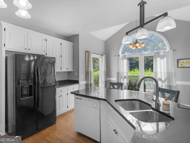 a kitchen with kitchen island granite countertop a sink stainless steel appliances and window