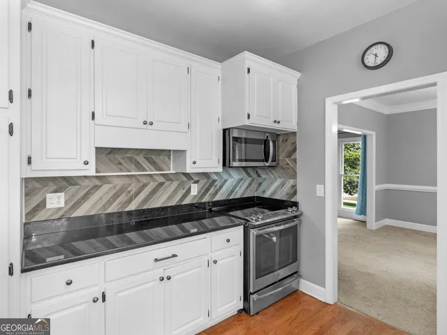 a kitchen with white cabinets and appliances