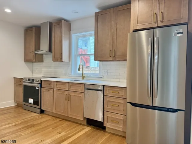 a kitchen with granite countertop stainless steel appliances and refrigerator