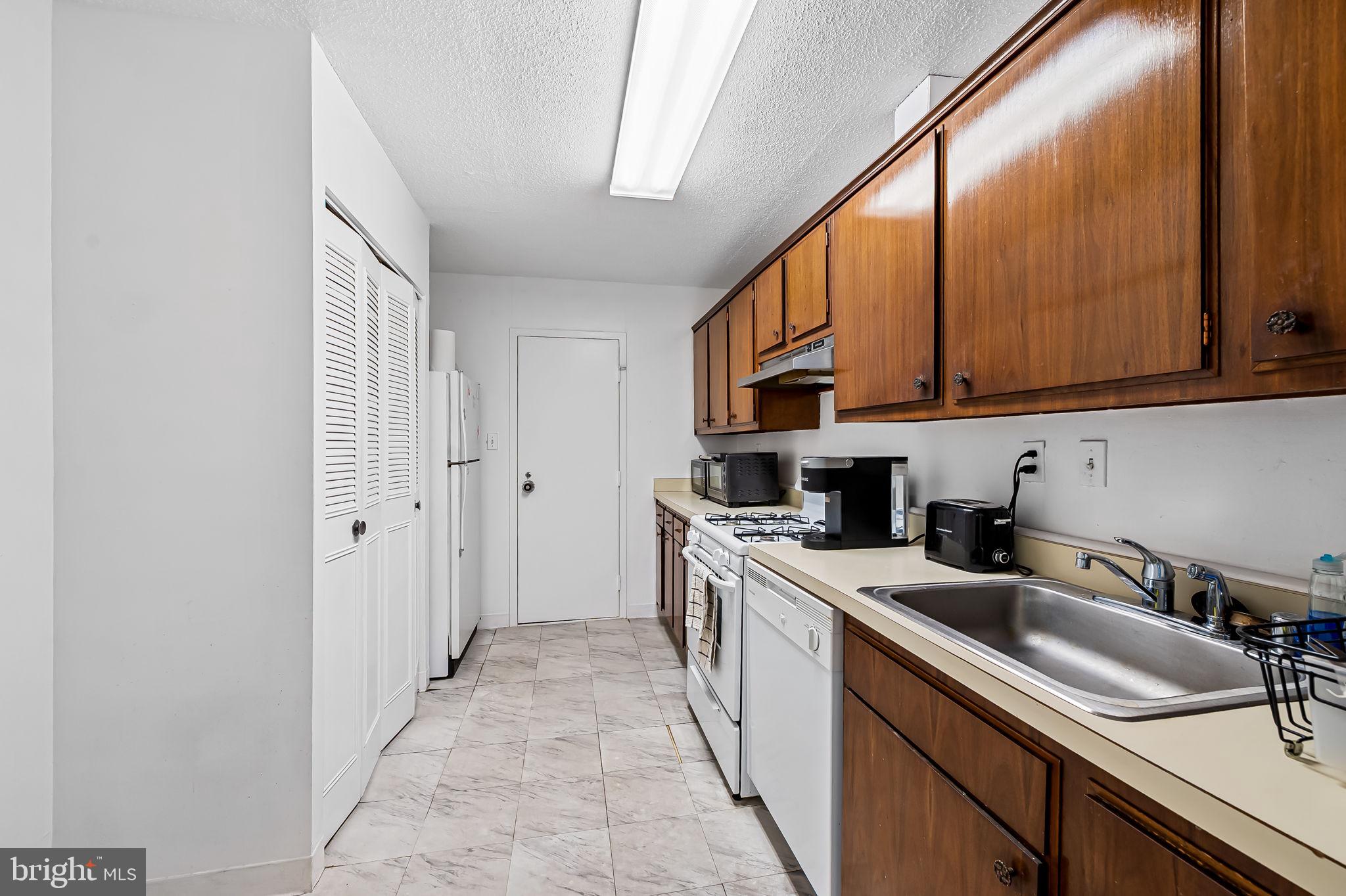 4401 Roland Avenue, Unit 110 Baltimore, MD 21210 - Photo 13 of 23 a kitchen with stainless steel appliances granite countertop a sink a stove and a refrigerator