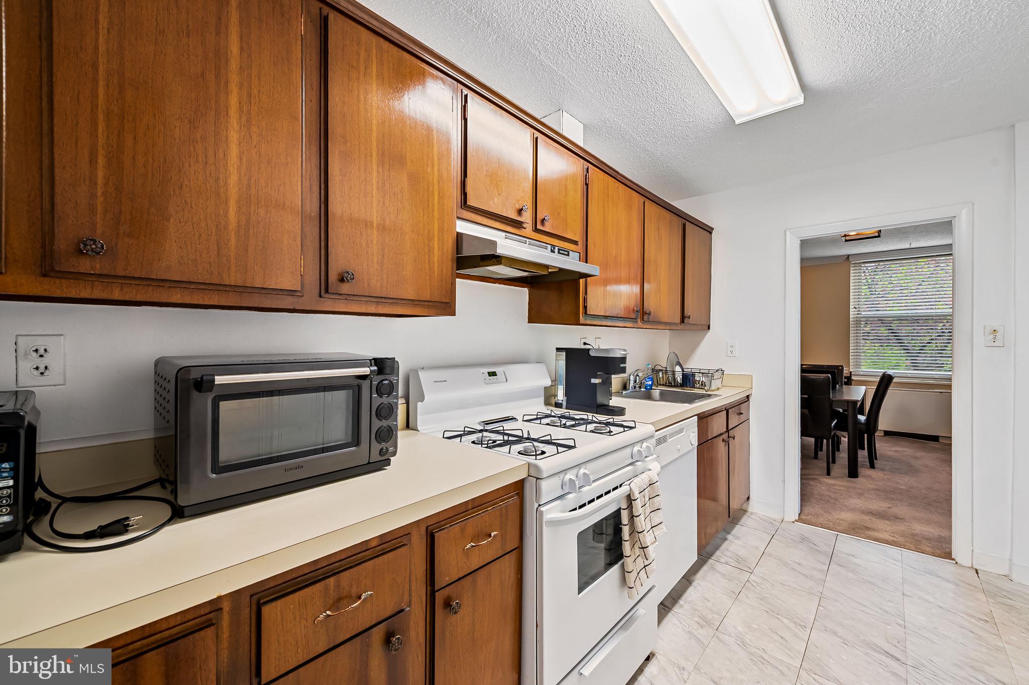 4401 Roland Avenue, Unit 110 Baltimore, MD 21210 - Photo 14 of 23 a kitchen with stainless steel appliances granite countertop a stove a sink and a microwave