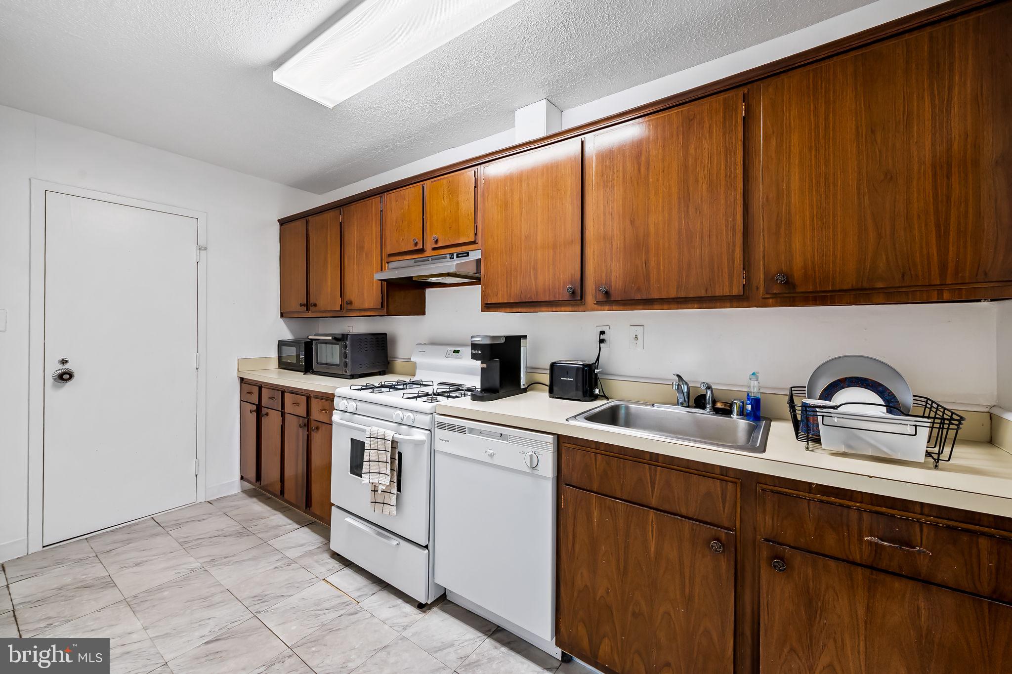 4401 Roland Avenue, Unit 110 Baltimore, MD 21210 - Photo 15 of 23 a kitchen with a sink stove and cabinets