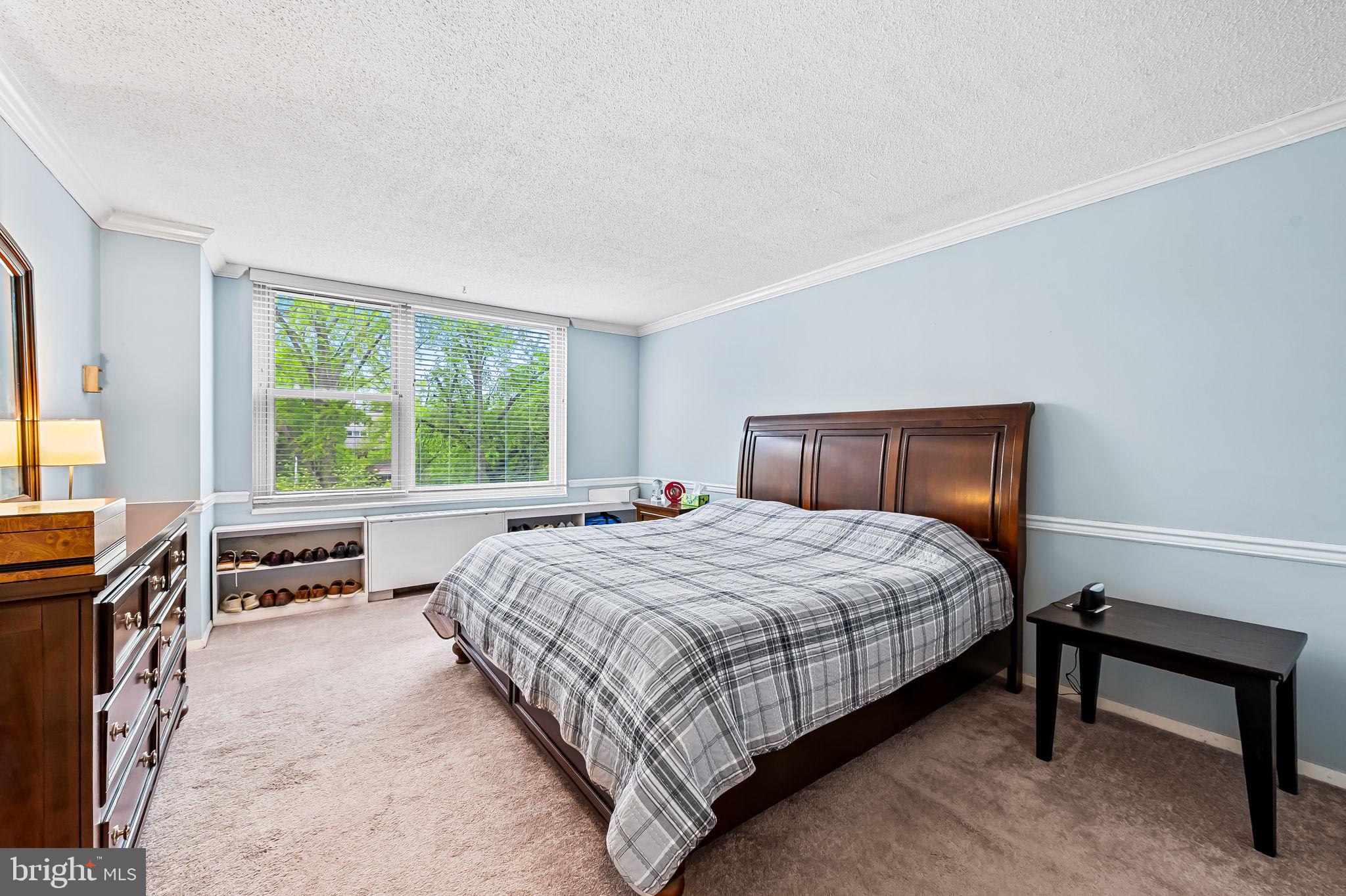4401 Roland Avenue, Unit 110 Baltimore, MD 21210 - Photo 17 of 23 a bedroom with a bed and a dresser next to a window