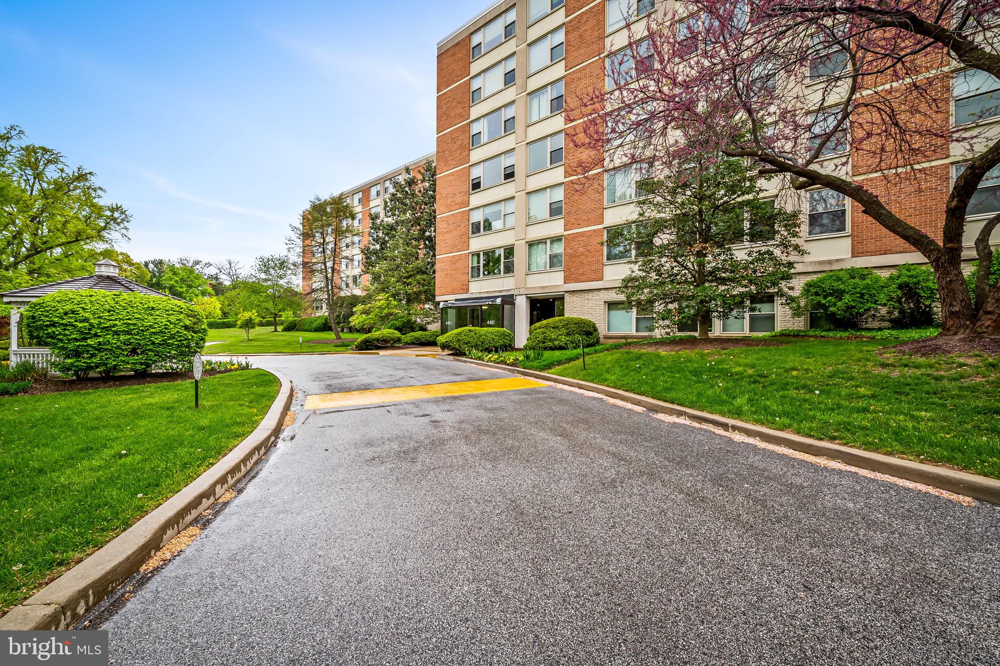 4401 Roland Avenue, Unit 110 Baltimore, MD 21210 - Photo 2 of 23 a view of a big building with a big yard and large trees