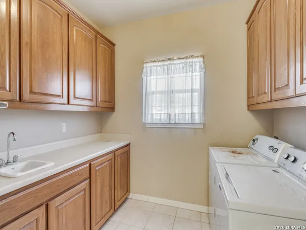 a utility room with sink dryer and washer