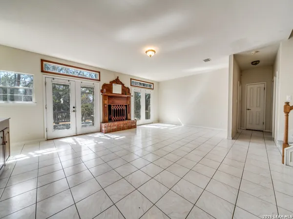 a view of an empty room with window and chandelier