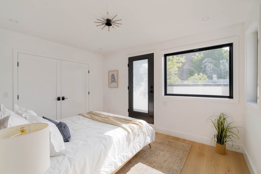 2 Soden Street, Unit 2 Cambridge, MA 02139 - Photo 16 of 38 a bedroom with a bed and a painting on the wall