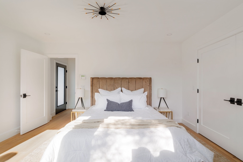 2 Soden Street, Unit 2 Cambridge, MA 02139 - Photo 18 of 38 a bedroom with a bed and mirror