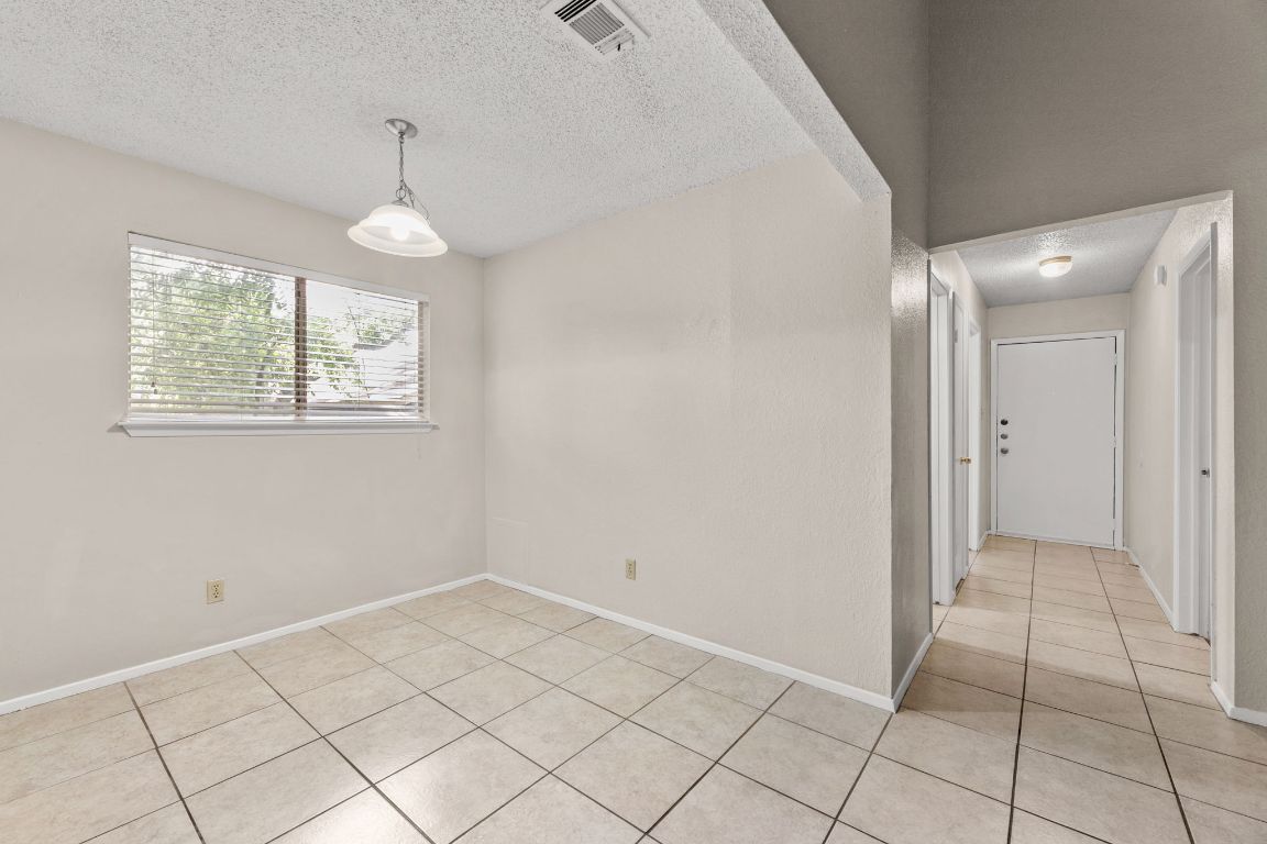 818 Sirocco Drive, Unit B Austin, TX 78745 - Photo 11 of 34 an empty room with chandelier fan and window