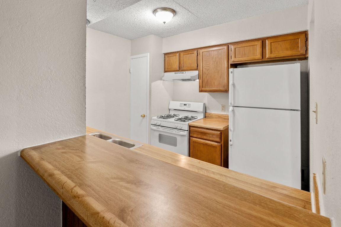818 Sirocco Drive, Unit B Austin, TX 78745 - Photo 15 of 34 a kitchen with a refrigerator a stove top oven and a refrigerator