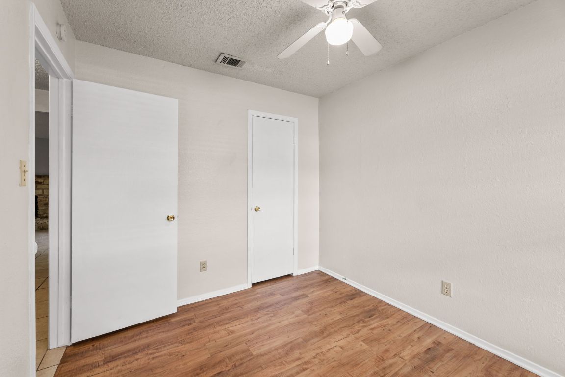 818 Sirocco Drive, Unit B Austin, TX 78745 - Photo 23 of 34 an empty room with wooden floor and fan