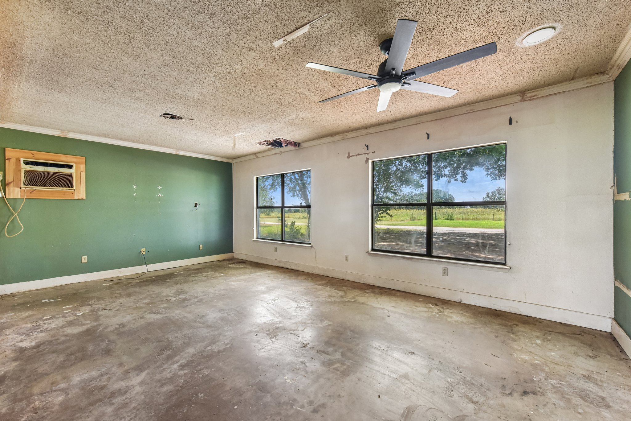 1111 Silent Valley Road Lockhart, TX 78644 - Photo 7 of 14 A spacious room offers ample potential for renovation, illuminated by natural light through expansive windows.