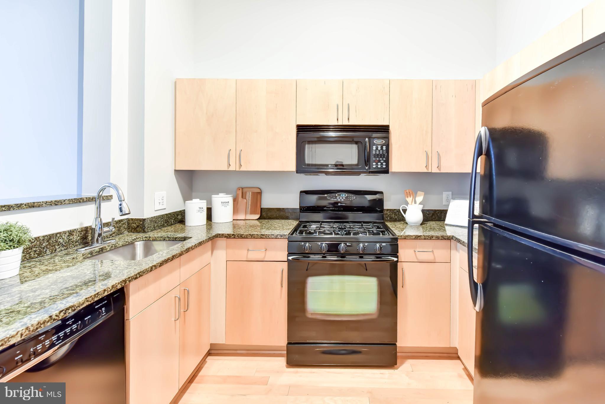 1000 New Jersey Avenue Southeast, Unit 108 Washington, DC 20003 - Photo 5 of 21 a kitchen with stainless steel appliances granite countertop a stove a sink and a refrigerator