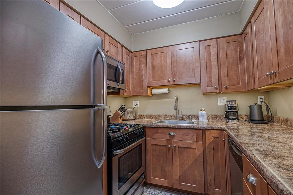 5 Bayard Road, Unit 621 Pittsburgh, PA 15213 - Photo 9 of 38 a kitchen with stainless steel appliances granite countertop a refrigerator sink stove and granite counter top