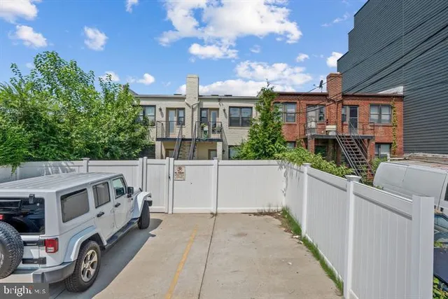 a view of a white house with large windows and a small yard