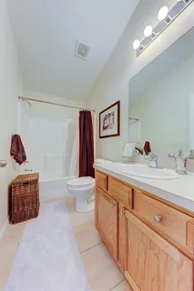 a spacious bathroom with a sink a toilet and a mirror