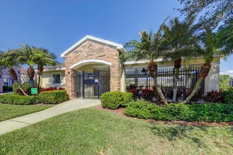 a view of a house with a small yard and a large tree