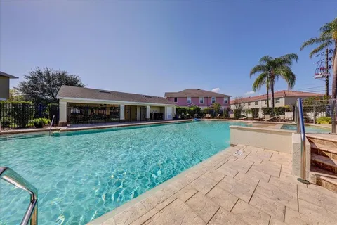 a view of a yard with plants and palm trees