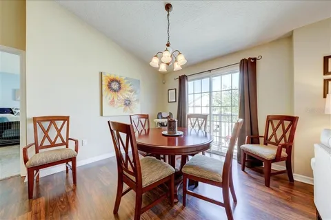 a dining room with furniture a chandelier and wooden floor