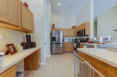 a kitchen with stainless steel appliances kitchen island granite countertop a refrigerator and a stove top oven